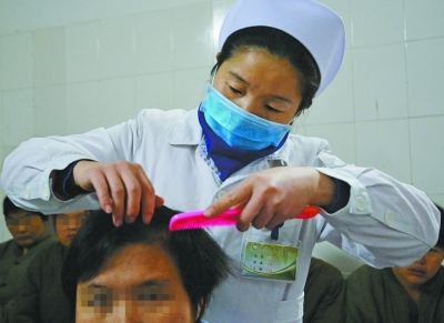 医务人员帮患者梳头。    记者胡伟鸣 摄